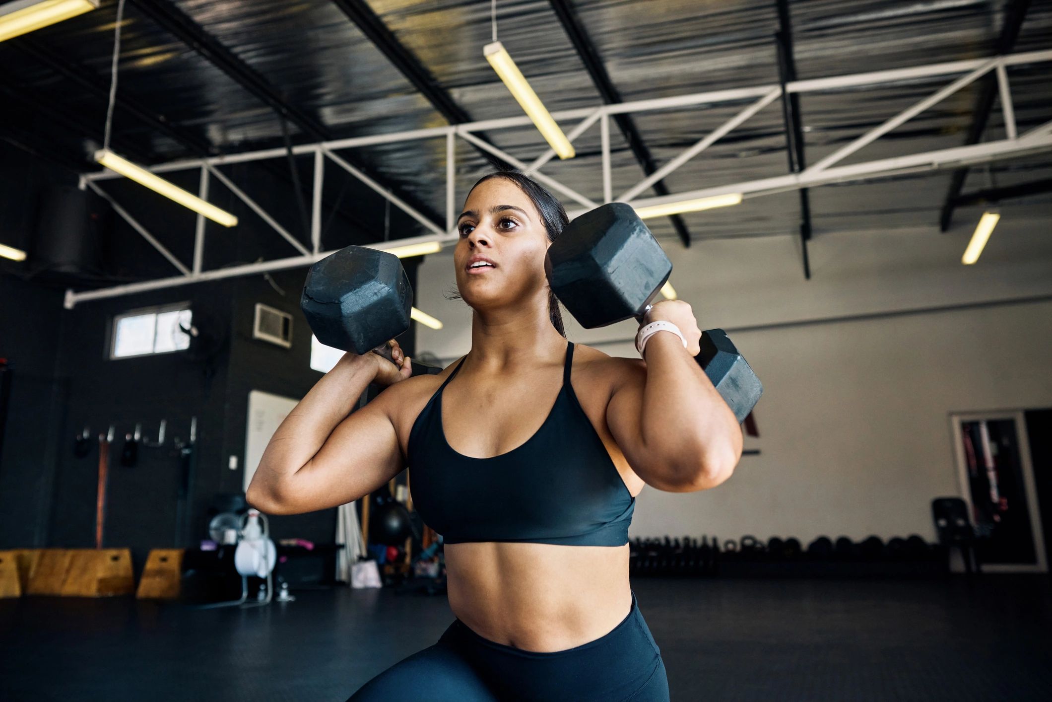 Sporcu dumbbell lunge ile kuvvet antrenmanı yapıyor