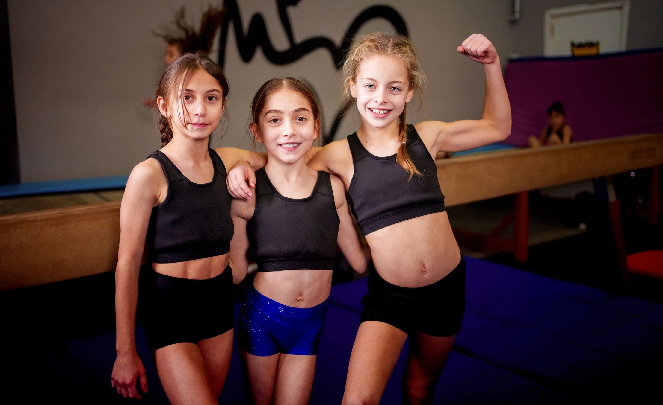 Spor salonunda birlikte poz veren genç sporcular