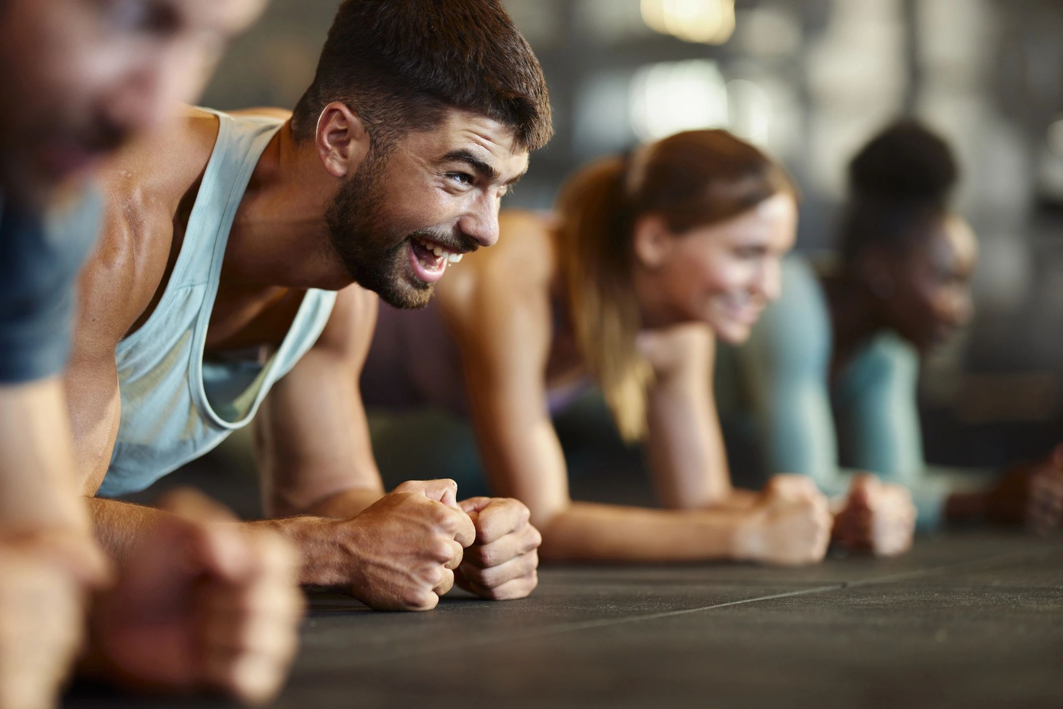 Spor salonunda plank pozisyonunda antrenman yapan grup